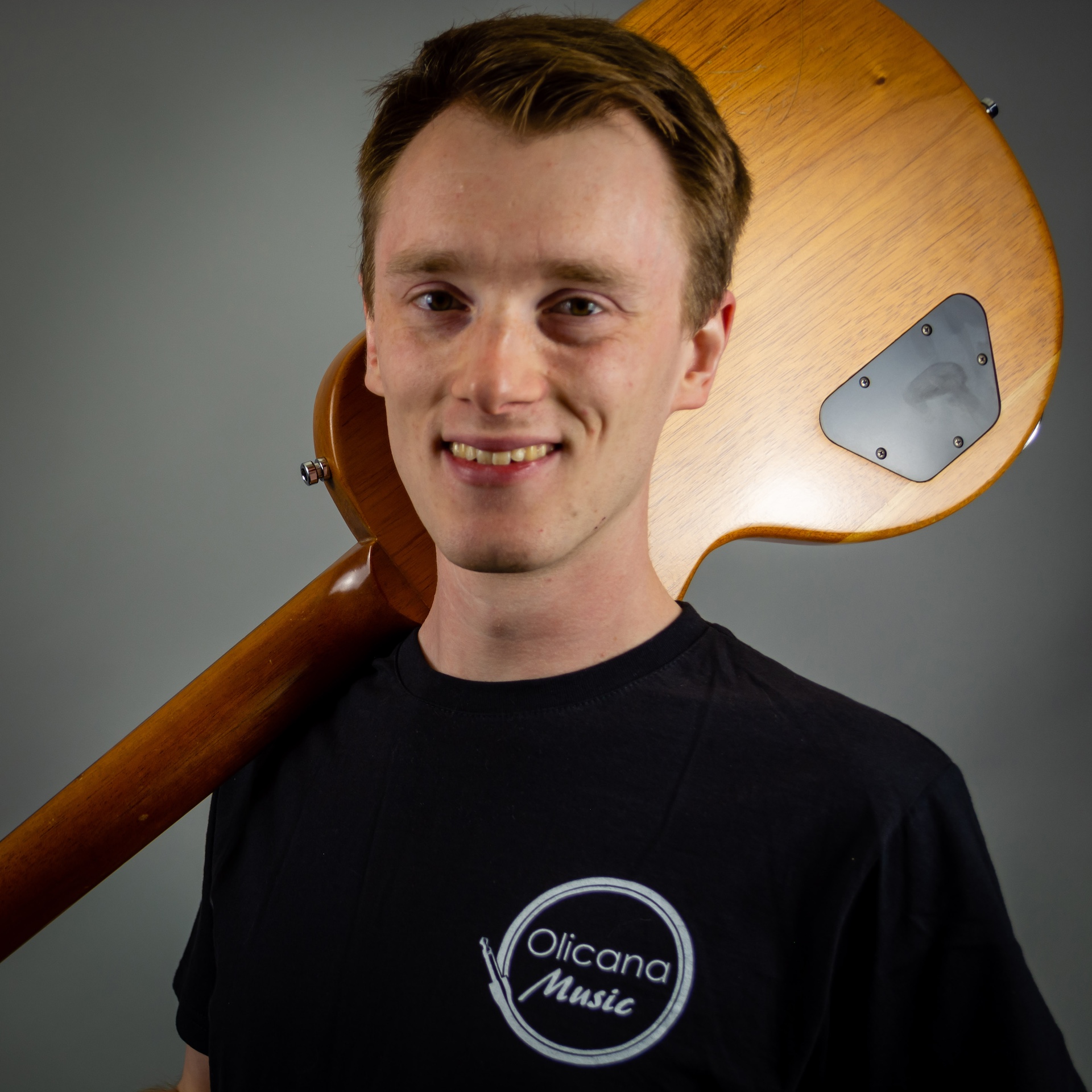 A portrait of Alasdair holding a unfinished Gordon smith GS2 over his right shoulder